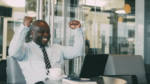 A business owner celebrating growth results at their desk